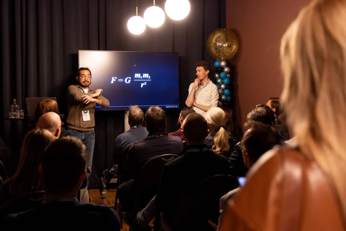 Fredric Lundberg speaking at a startup event, Newton's law of gravitation on the screen