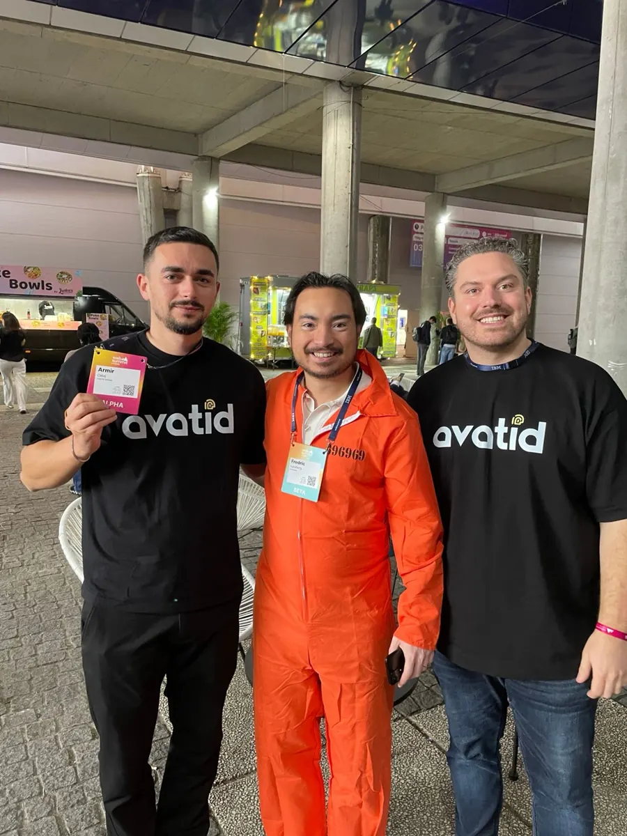 Fredric Lundberg in an orange prison jumpsuit with two founders at Web Summit 2025