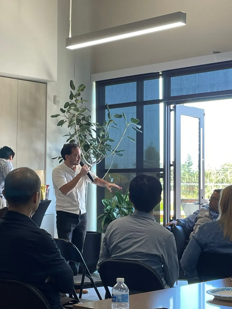Fredric Lundberg speaking with a microphone at an event in the Bay Area
